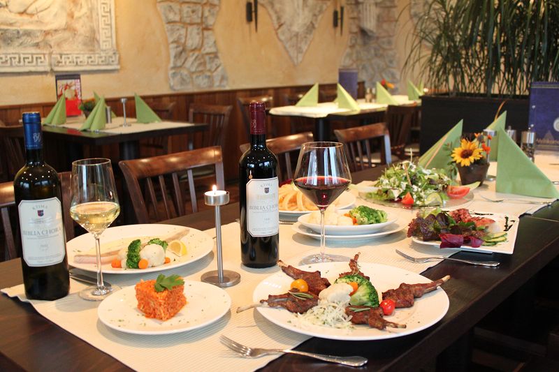 Angerichteter Tisch mit Lamm, Salat und Wein
